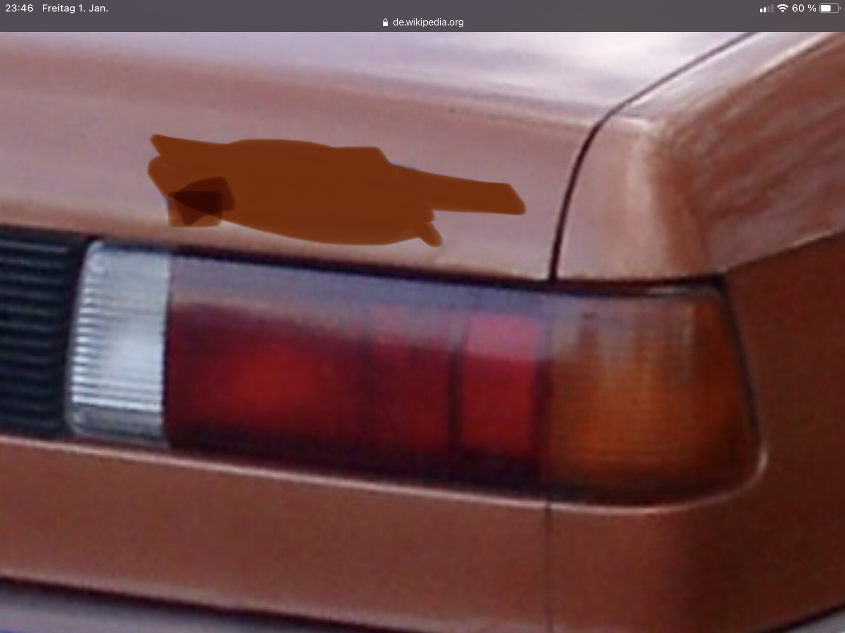 Nahaufnahme eines braunen Autos mit rotem Rücklicht, seitlich aufgenommen.