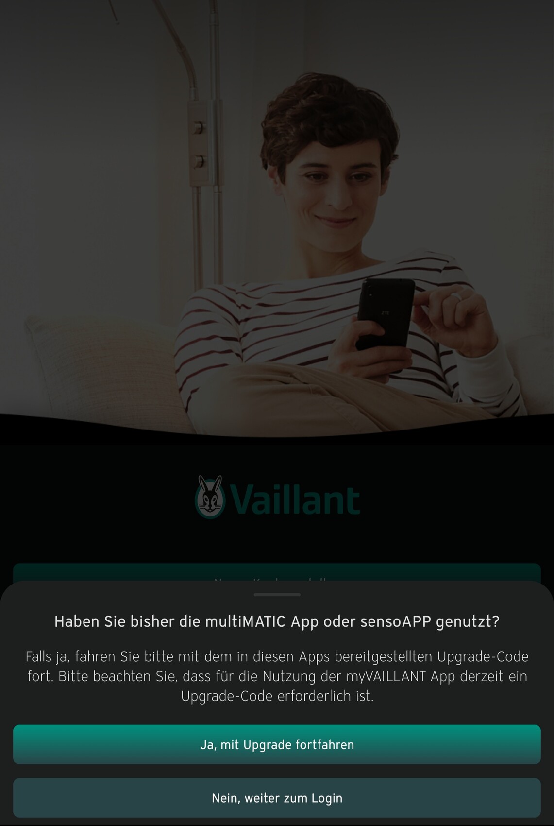Eine Person sitzt auf dem Sofa und schaut auf ihr Smartphone.