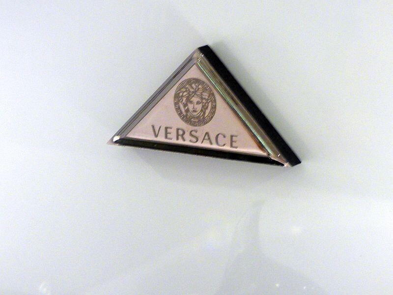 Rosa Dreieckslogo von Versace auf hellem Hintergrund
