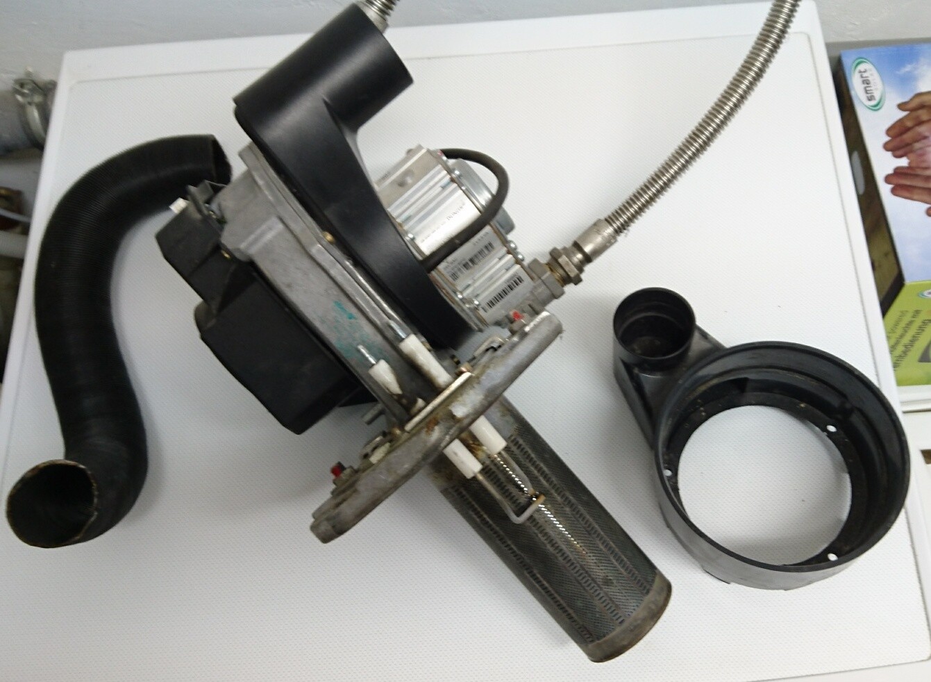 Nahaufnahme eines Haustechnik-Pumpenmoduls mit Schlauchanschlüssen und Dichtungen auf weißer Oberfläche