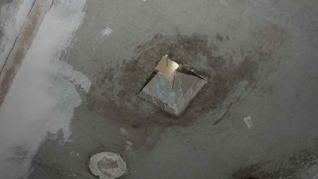Quadratische Öffnung im rohen Betonboden eines Bauprojekts