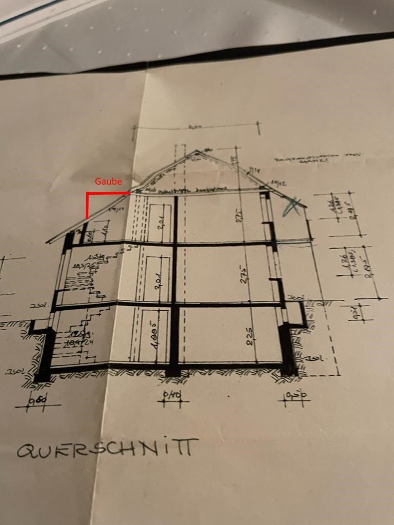 Querschnitt eines mehrstöckigen Hauses mit Dachgaube und Maßangaben.