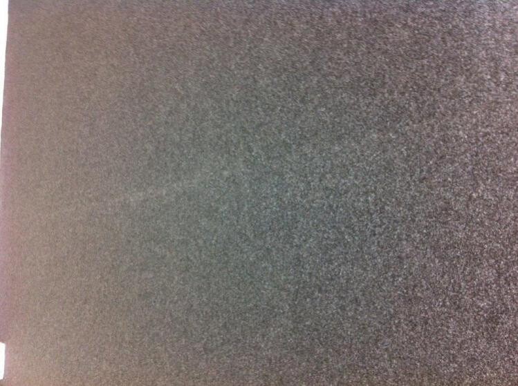 Nahaufnahme einer rauen grauen Putzoberfläche mit feiner Struktur.