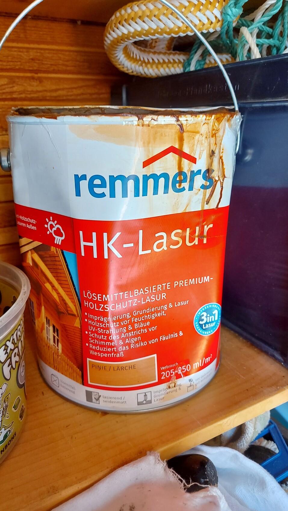 Farbdose Remmers HK-Lasur Holzschutzlasur mit rotem Etikett auf Holzregal.