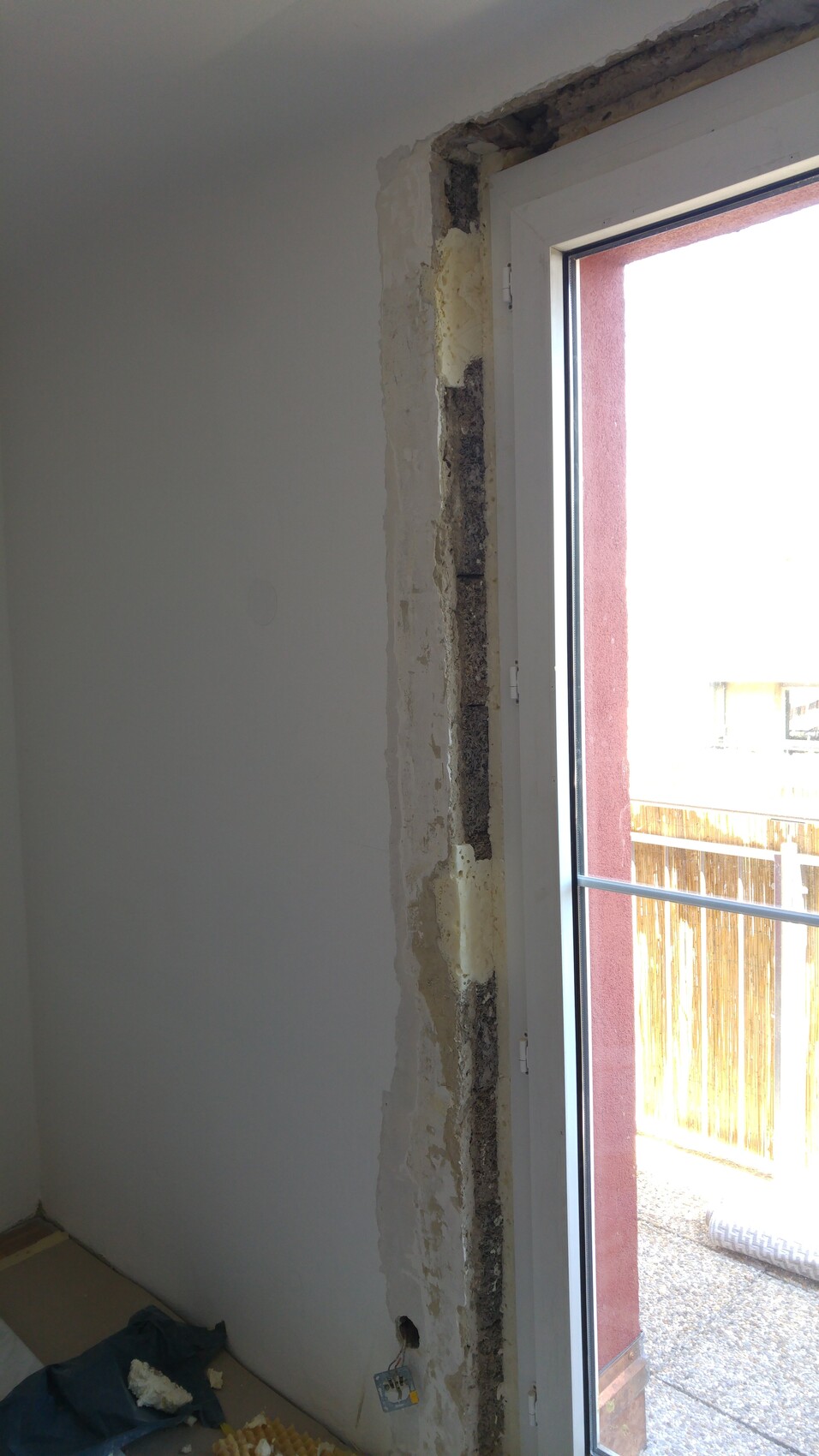 Renovierungsarbeiten im Innenraum mit freigelegter Wand und Fensterrahmen