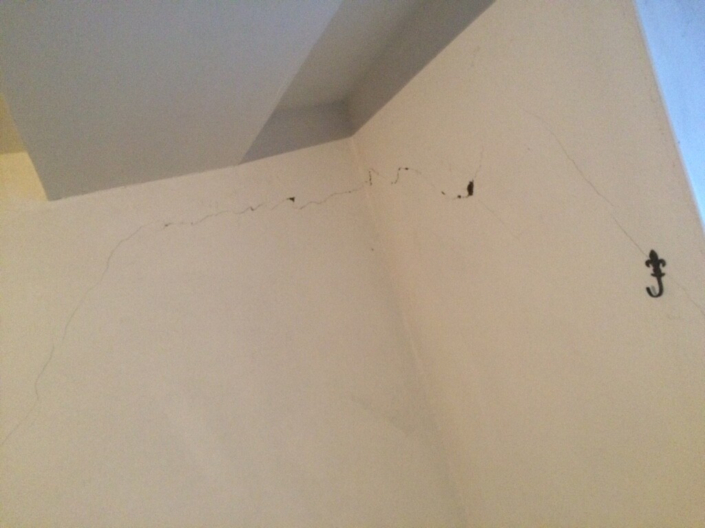 Innenwand mit Rissen und Cracklinien an der Decke, Baubeschädigung sichtbar