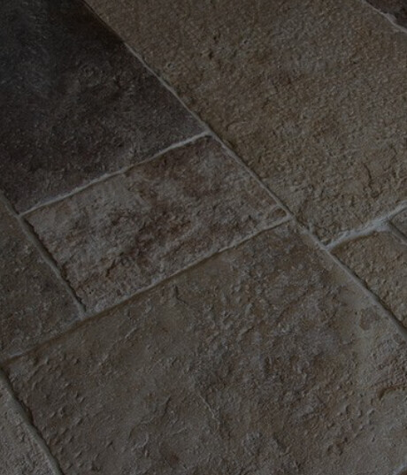 Nahaufnahme brauner Steinplattenfläche mit fliesenartiger Struktur und rauer Textur