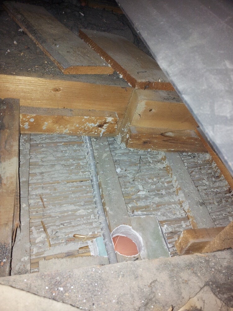 Unfertiger Dachboden mit Holzbalken, Dämmung und Rohrleitung