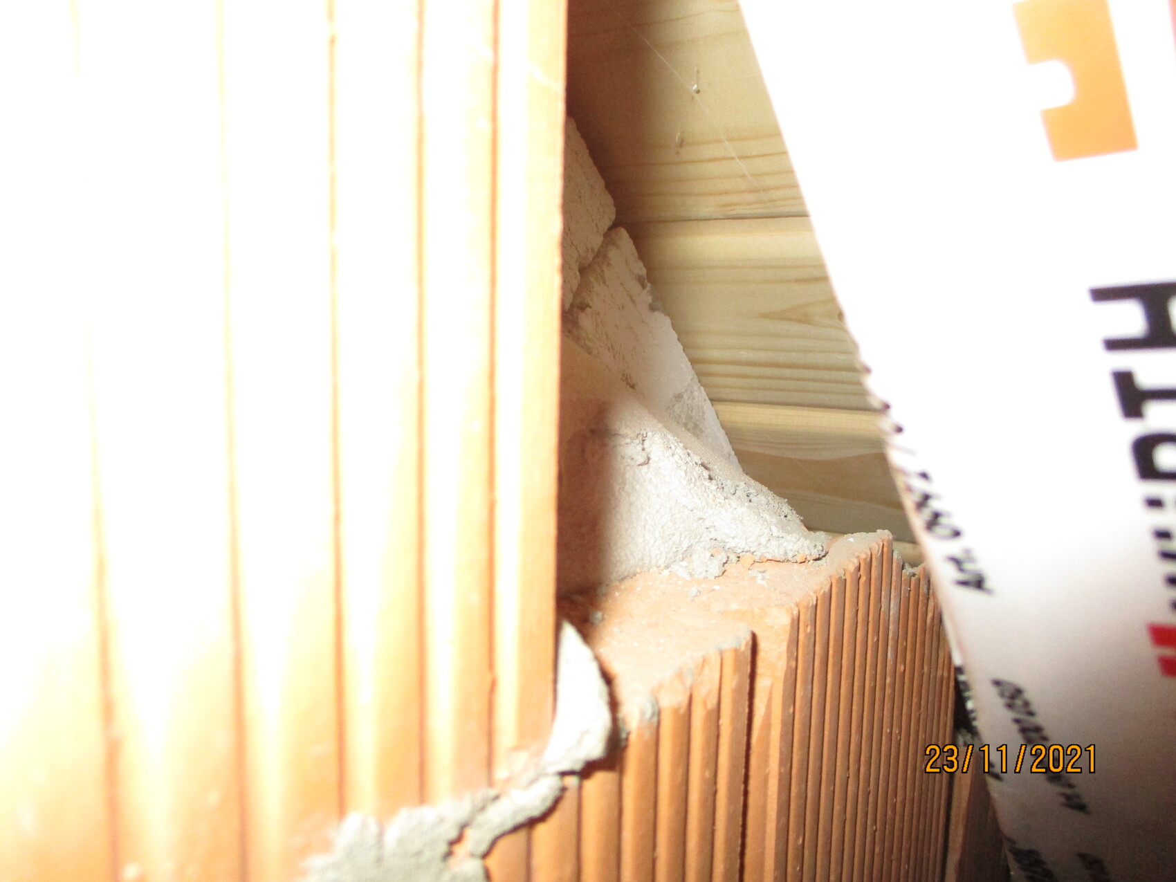 Nahaufnahme einer Rohbauwand aus Backstein mit Mörtel und Bauwerkstoffen.