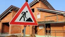 Rohbau Baustelle mit Warnschild vor einem im Bau befindlichen Haus