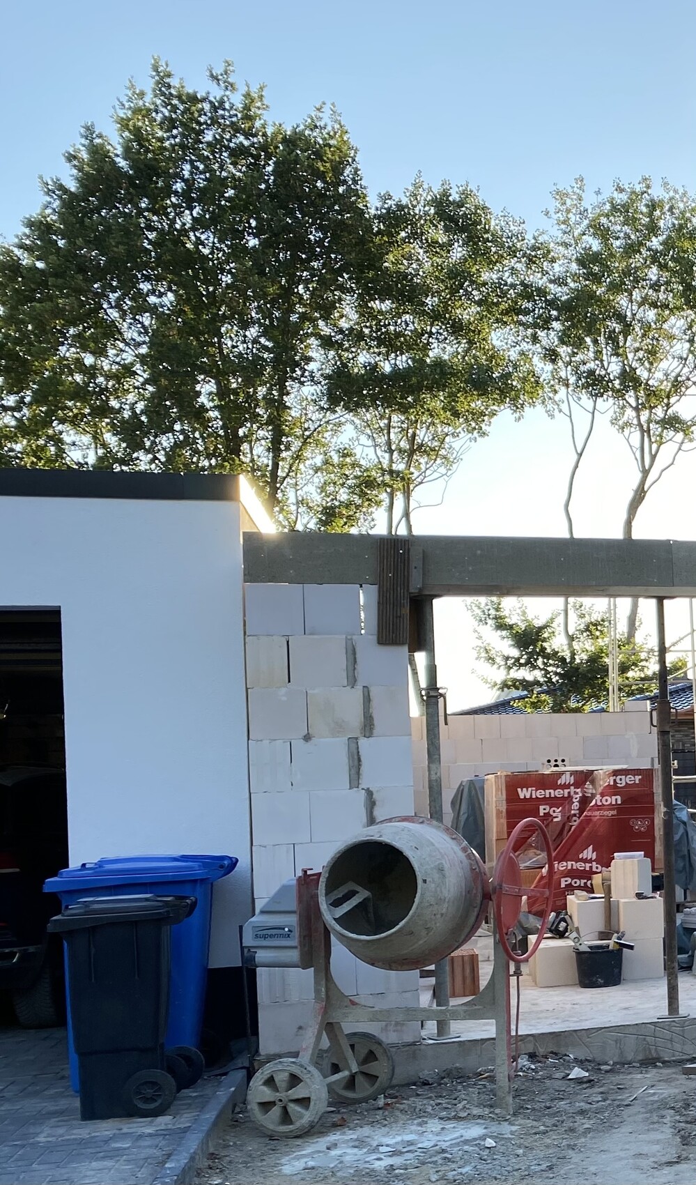 Baustelle mit Betonmischer, Blöcken und Baugeräten im Freien