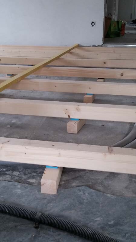 Holzbalken auf Fundamentstehern als Bodenunterkonstruktion im Rohbau