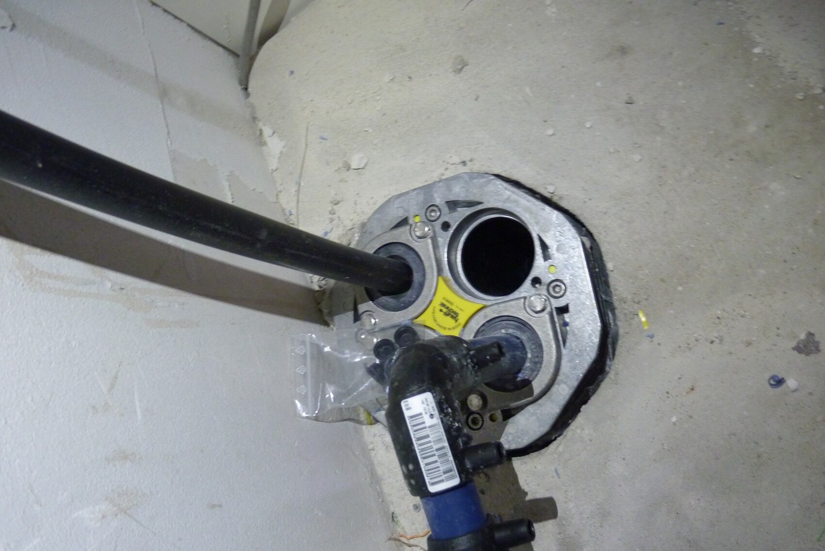Rohbau-Boden mit Rohranschluss und Installationsplatte, sichtbare Wasserleitungen