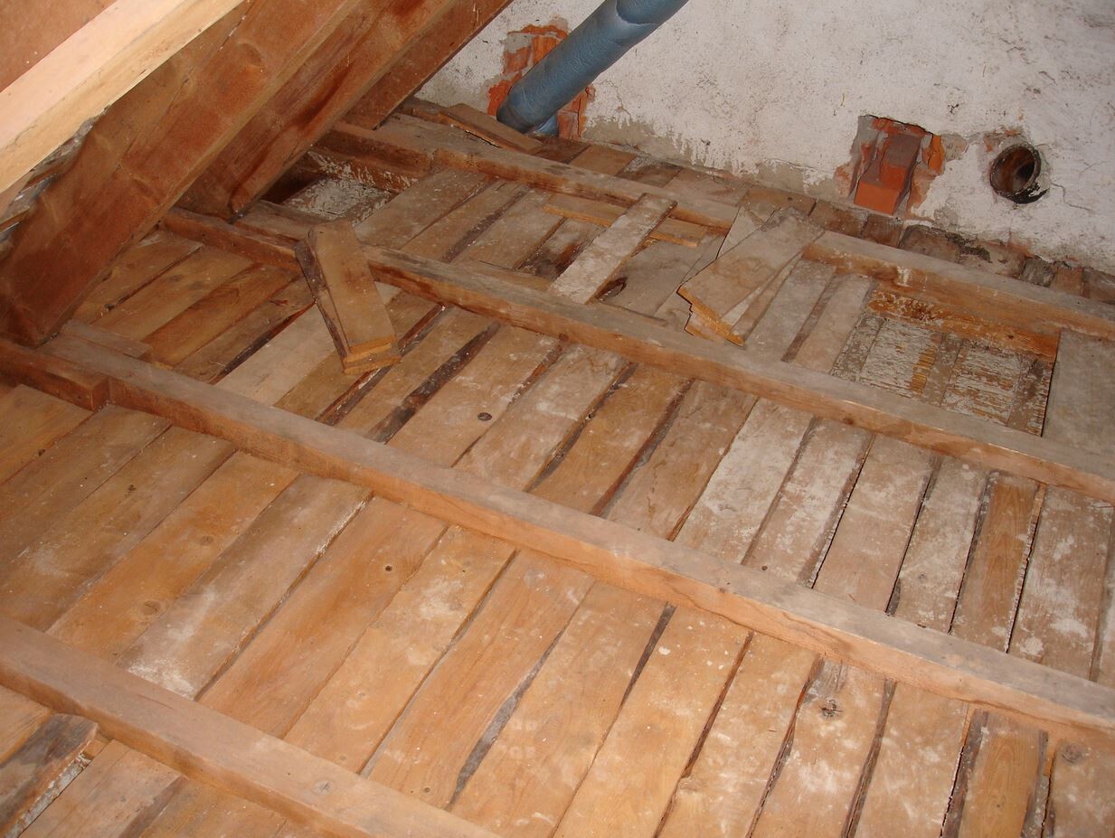 Dachgeschoss-Rohbau mit Holzböden und Holzbalken, Bauarbeiten im Dachboden