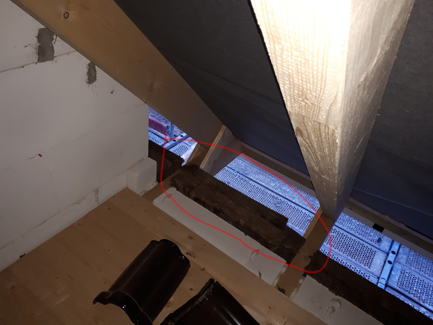 Dachboden: offener Spalt mit verrottetem Holzbalken zwischen Sparren; blaue Außenplattform sichtbar.