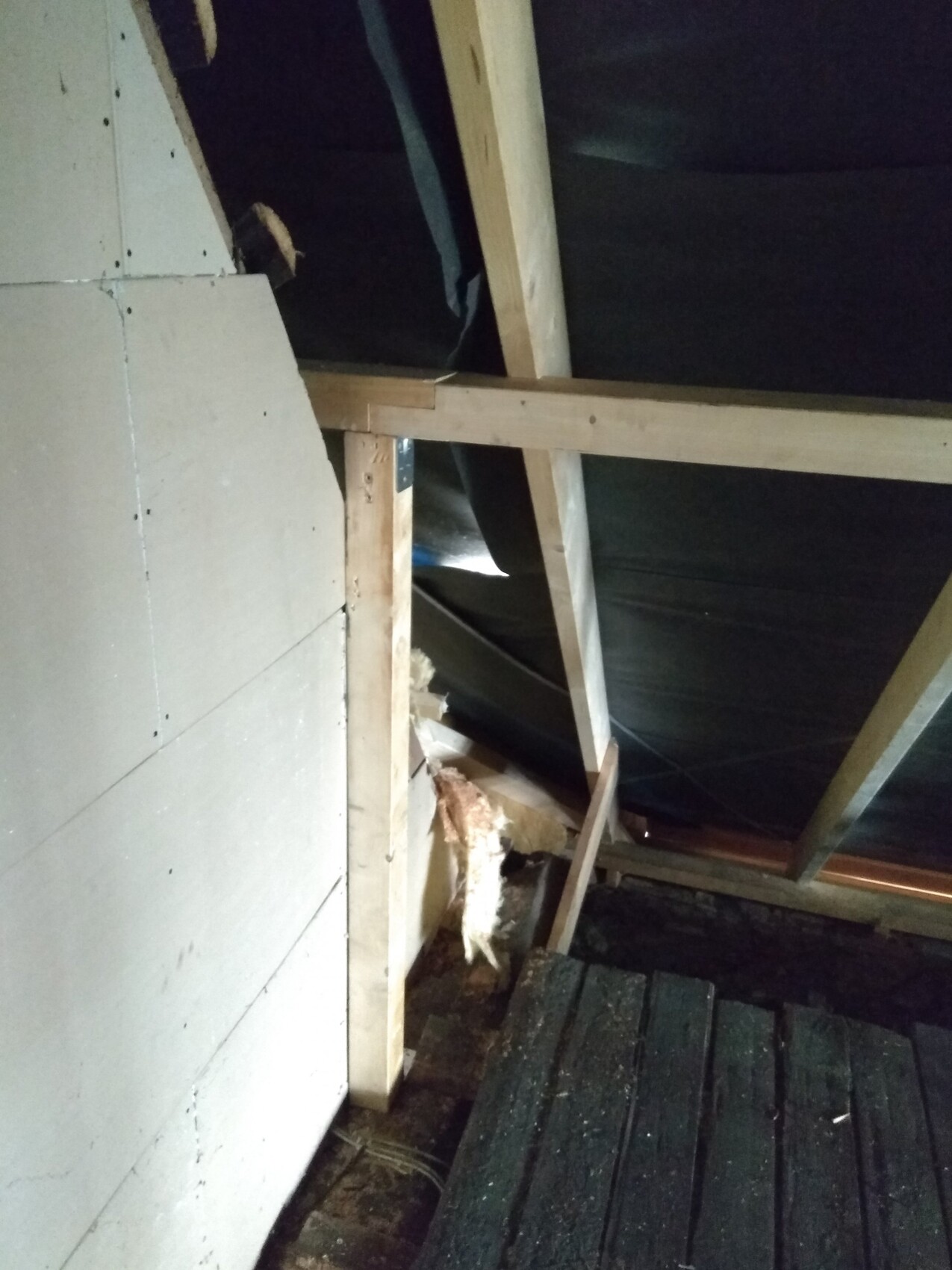 Dachboden mit Holzsparren, unverkleidete Dachkonstruktion und Dämmmaterial