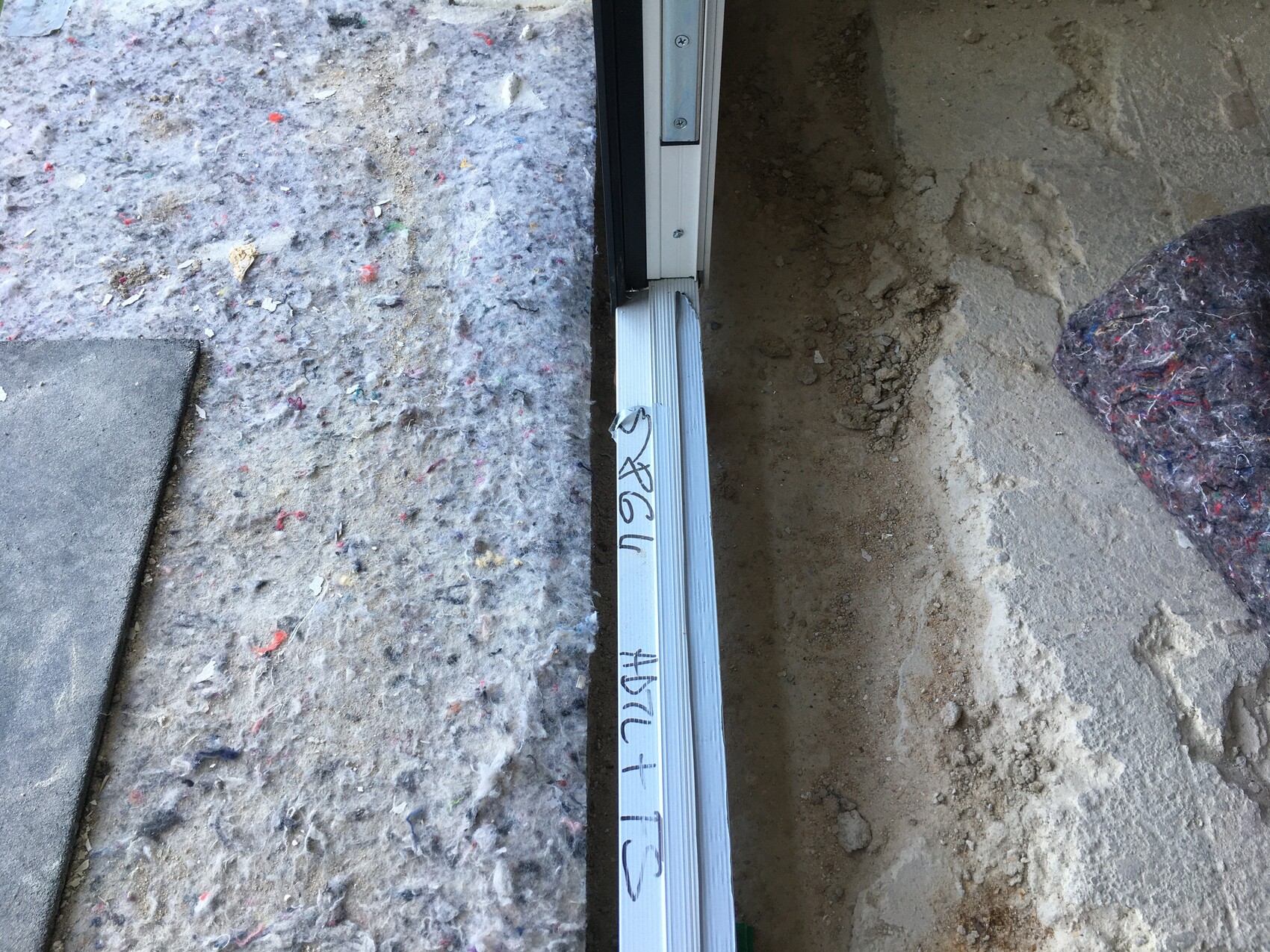 Offener Türrahmen an einer Rohbaustelle mit Metall-Schwelle und Erdreich