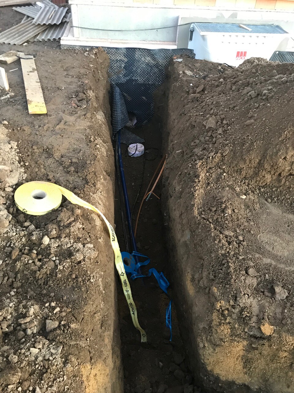 Baugrube mit Fundamentanschluss und installierten Rohrleitungen auf Baustelle