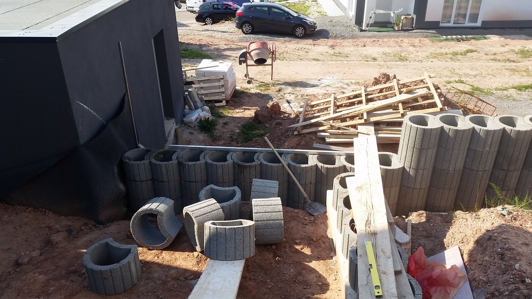 Baustelle mit Betonblöcken, Baumaterialien und Schutt am Rohbaufundament