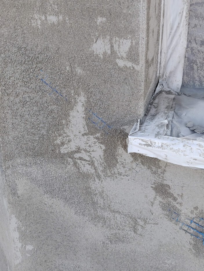 Rohbau: Sichtbare Betonwandkante, Fundament und Abdeckfolie am Bau