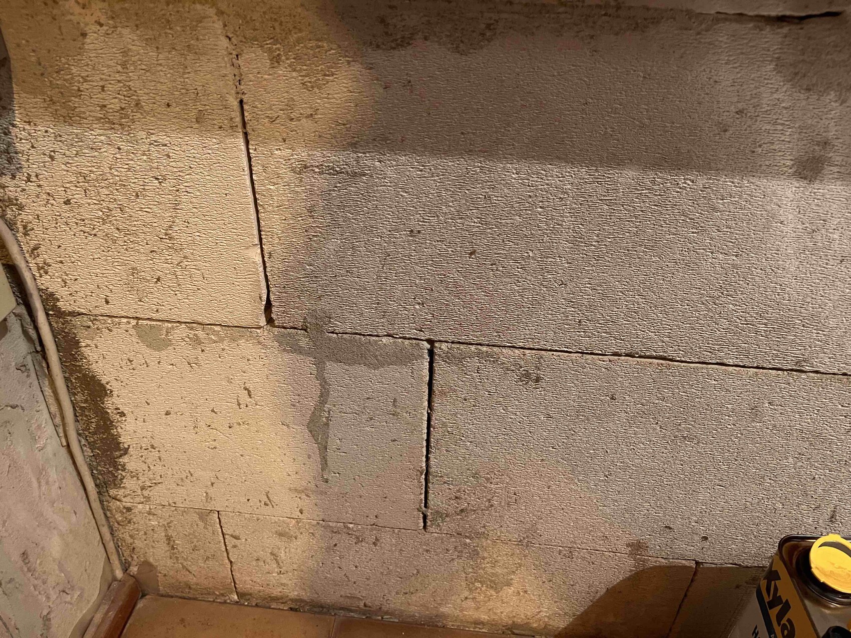 Betonblockwand im Rohbaufundament mit Rissen im Kellerbereich