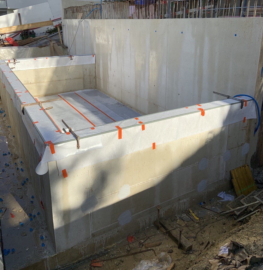 Betonfundament eines rechteckigen Beckens im Bau; Formrahmen, orange Markierungen sichtbar