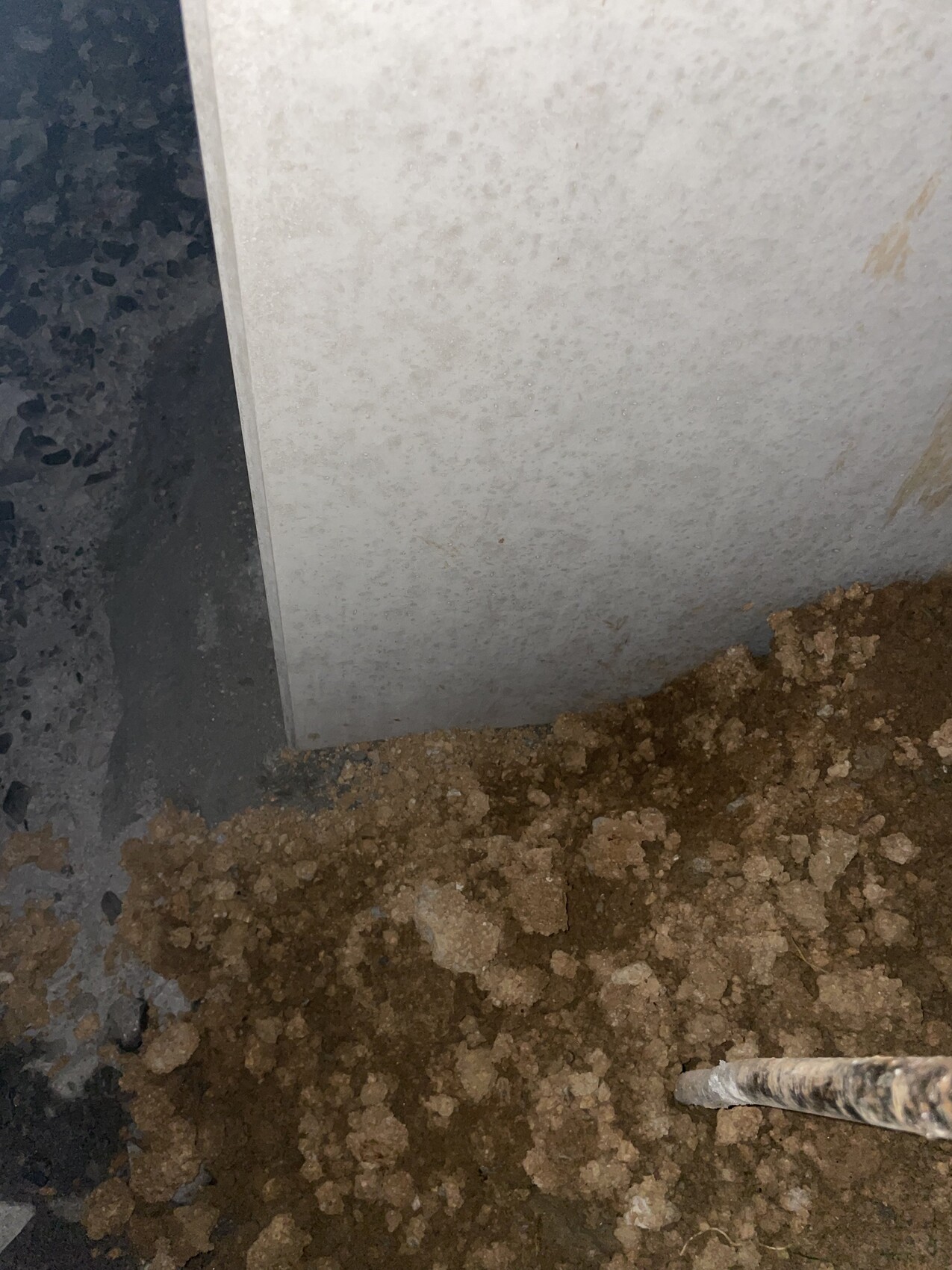 Baustelle mit Betonwand und Erdreich am Fundament