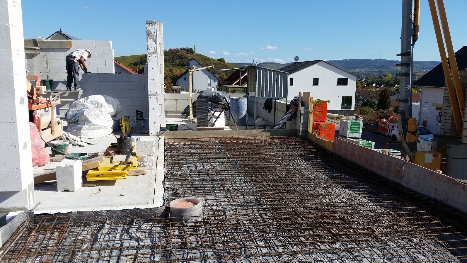 Bauarbeiter verlegt Bewehrung auf einer Rohbau-Deckenplatte auf einer Baustelle.