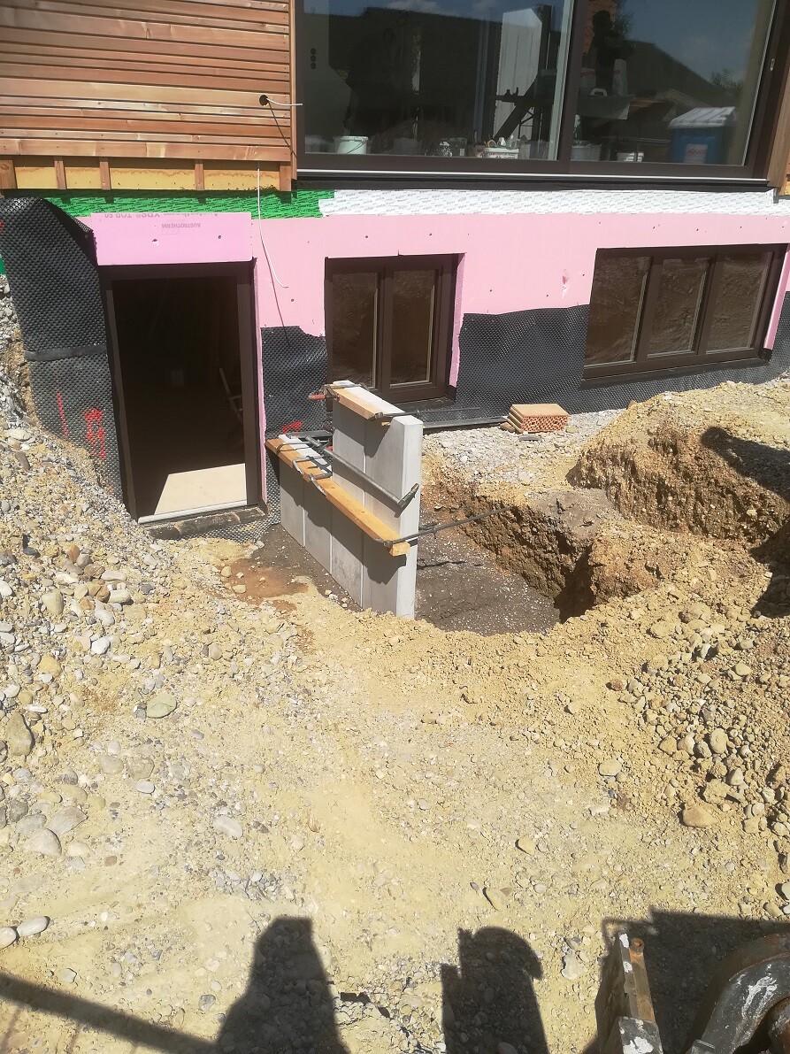Baustelle am Haus: Kellereingang, Fenster, Wandisolierung, Erdarbeiten.