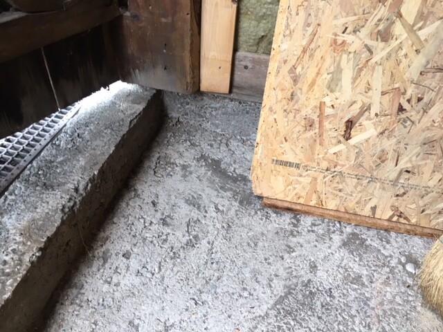 Rohbau-Fundament im Kellerraum mit Holzrahmen und grobem Betonboden