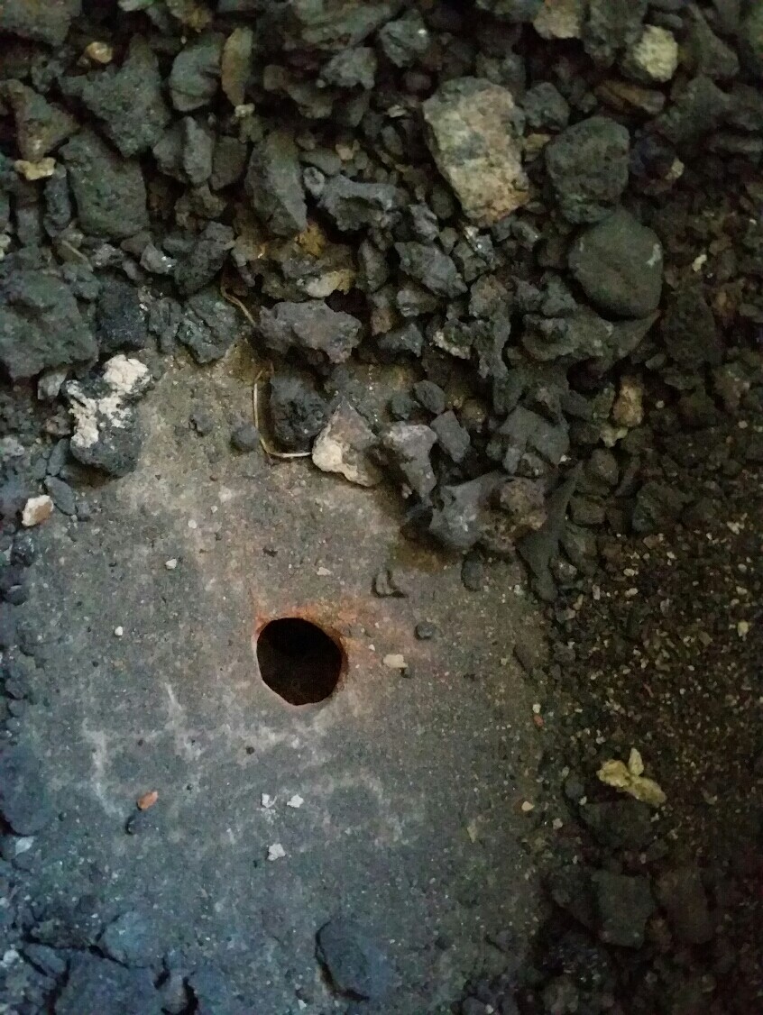 Betonfundament mit Loch und umliegendem Baustellen-Schutt