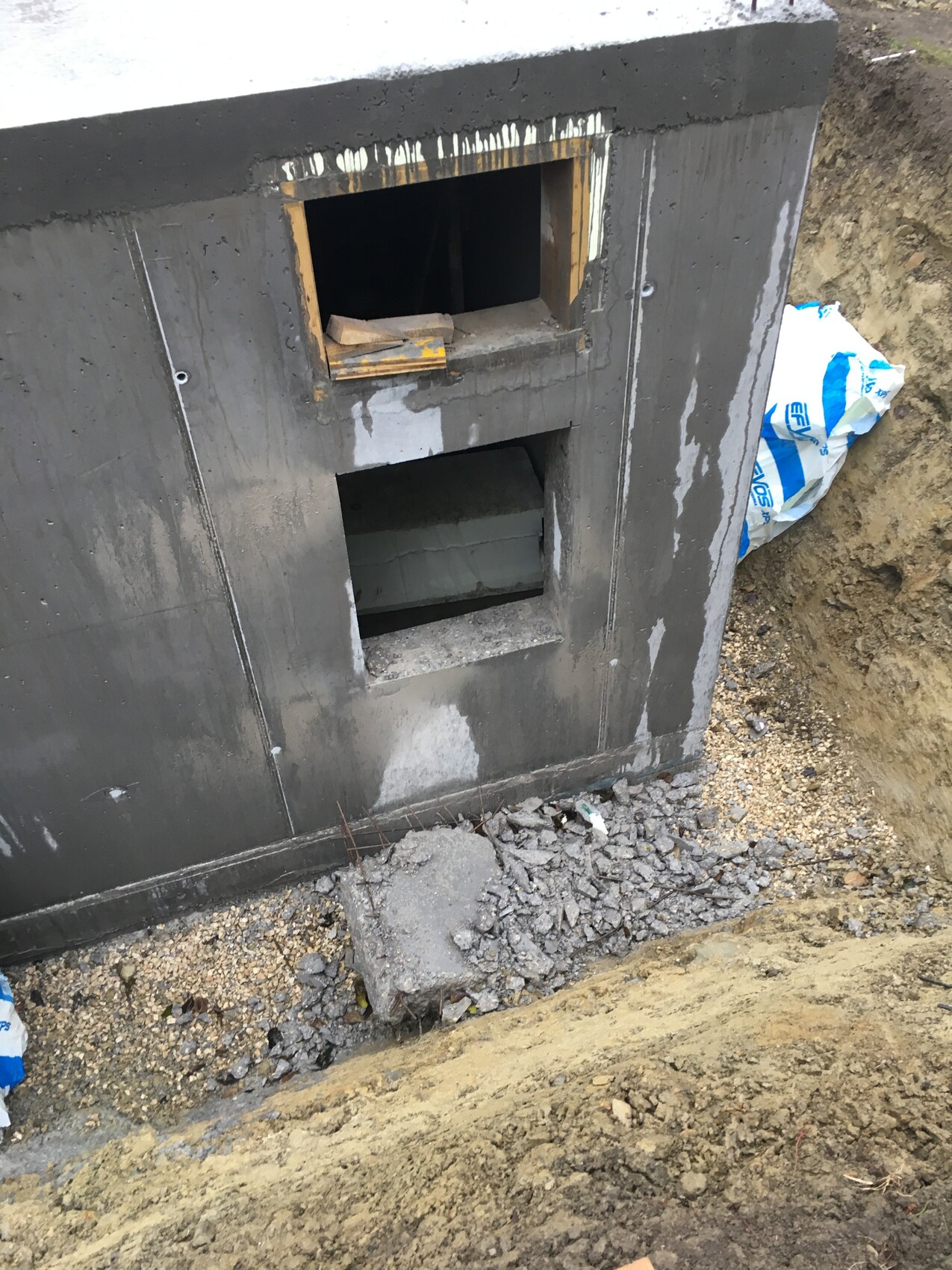 Rohbau-Fundament mit Öffnungen im Betonwandabschnitt am Baugrund