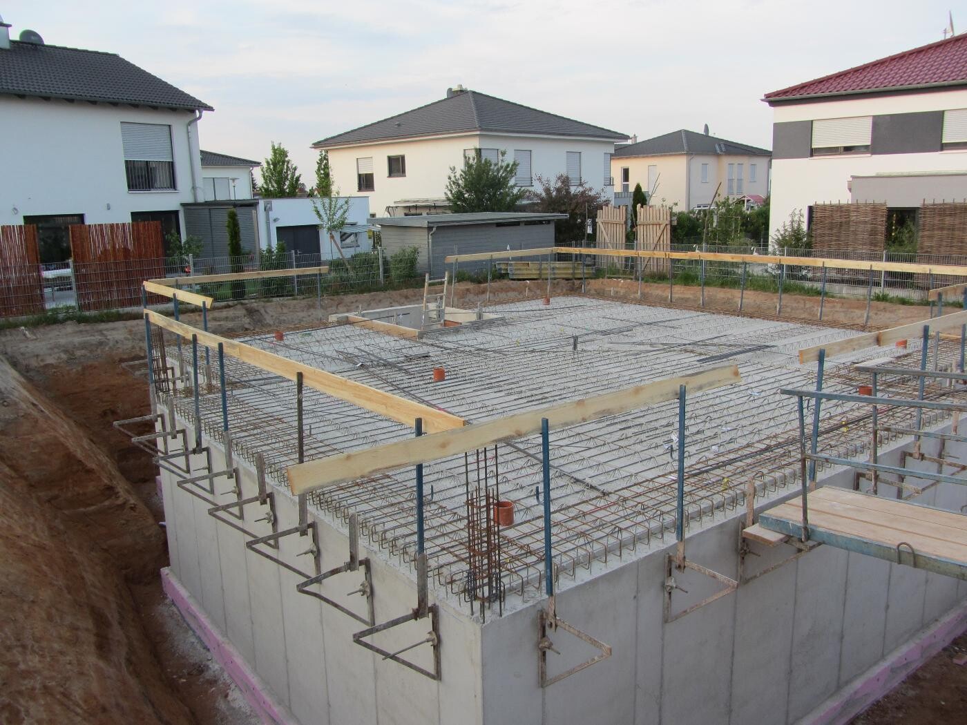 Fundament mit Stahlbewehrung auf Baustelle in Vorstadtviertel.