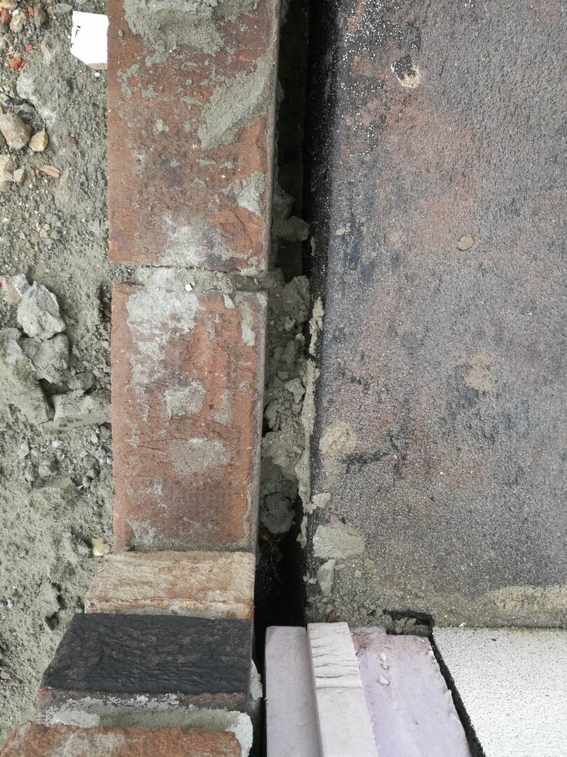 Baustelle mit Ziegelsteinfundament und Bauarbeiten am Rohbau