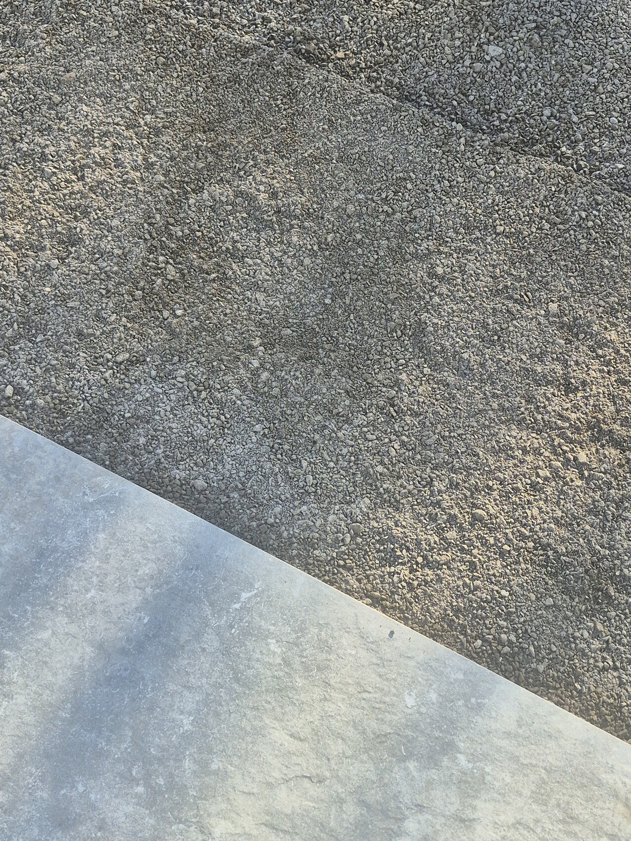 Baustellenaufnahme: Kiesboden mit diagonaler Betonplatte