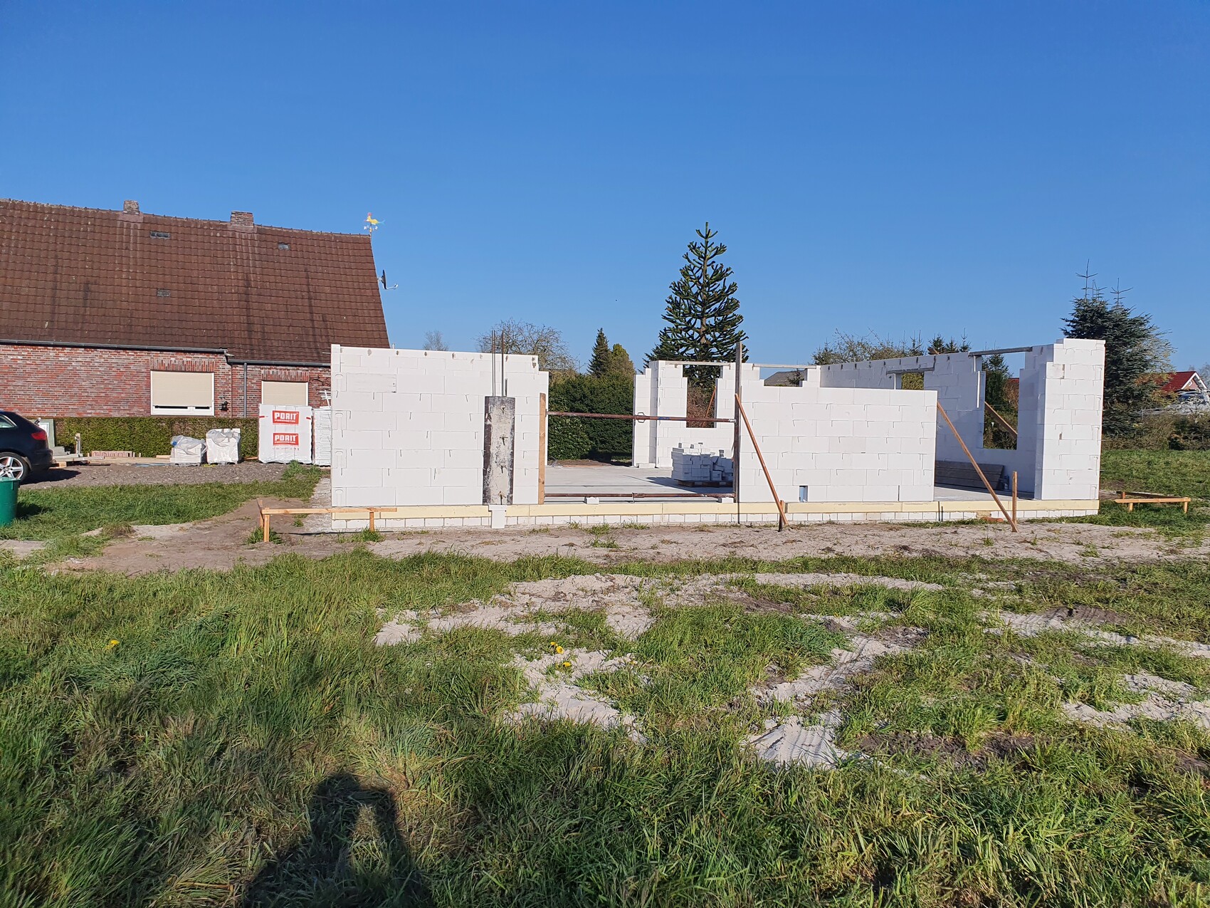 Unfertiges Gebäude aus weißen Porenbetonsteinen mit offenen Wänden auf einer Baustelle.