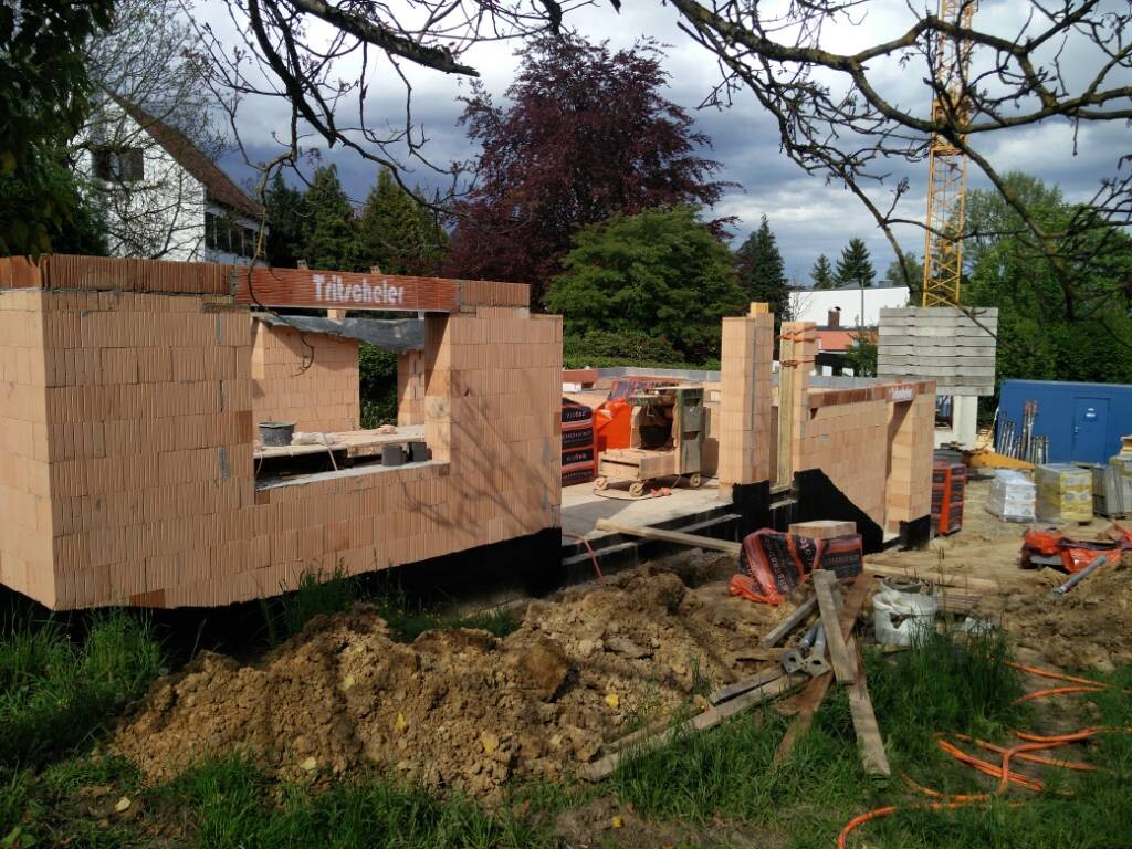 Baustelle mit unfertigen Ziegelwänden im Rohbau eines Hauses auf Bauplatz
