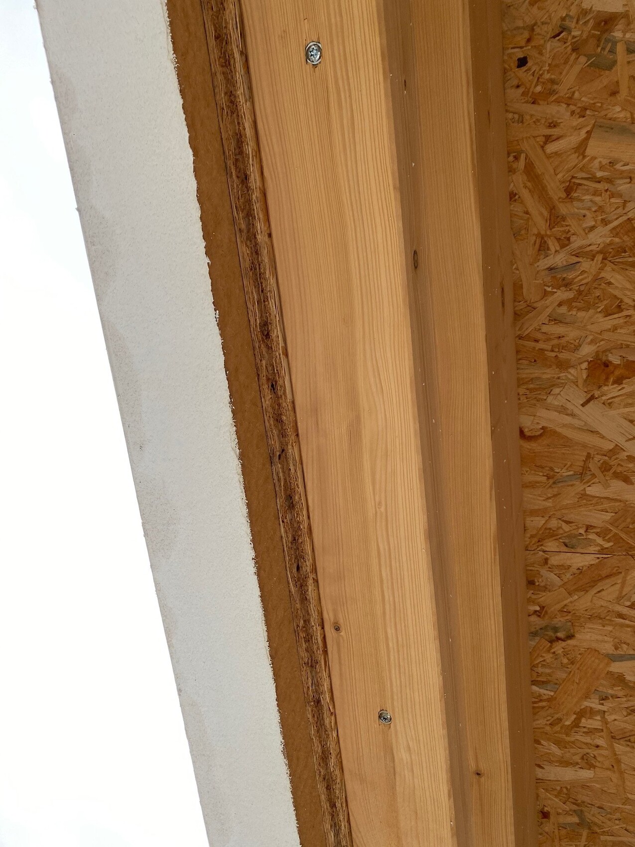 Holz-Türzarge an einer Baustellenwand mit OSB-Verkleidung, sichtbare Schrauben.