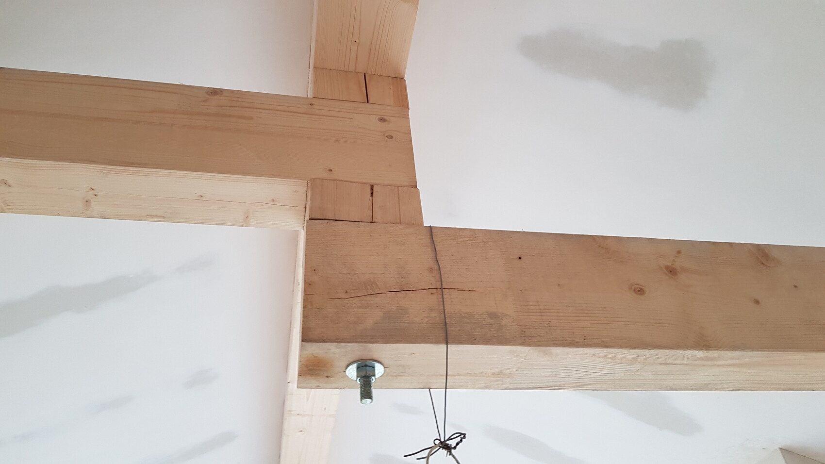 Holzträger und Bauholz im Rohbau-Deckenbereich mit Schraubbolzen