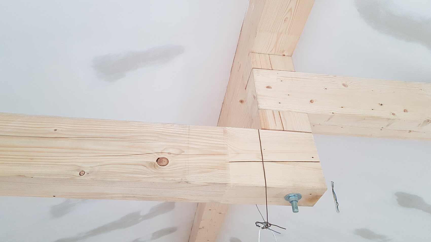 Holzbalkenkonstruktion im Rohbau eines Hauses, sichtbare Verbindungen