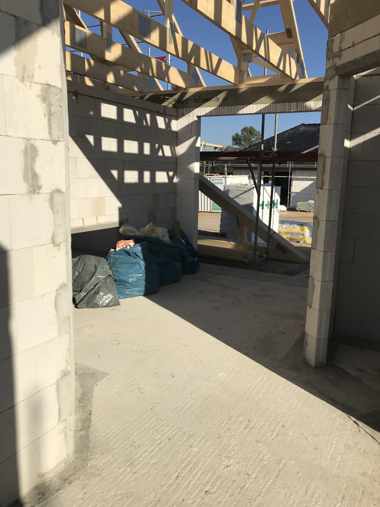 Rohbau Innenansicht einer Baustelle mit Betonblöcken und Holzträgern.