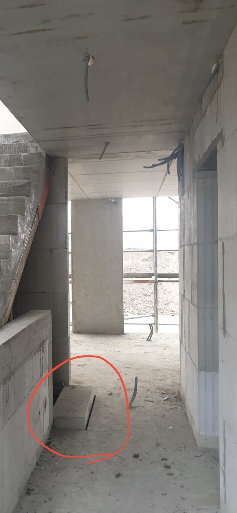 Innenansicht eines Rohbaus mit Treppe und offenen Betonwänden