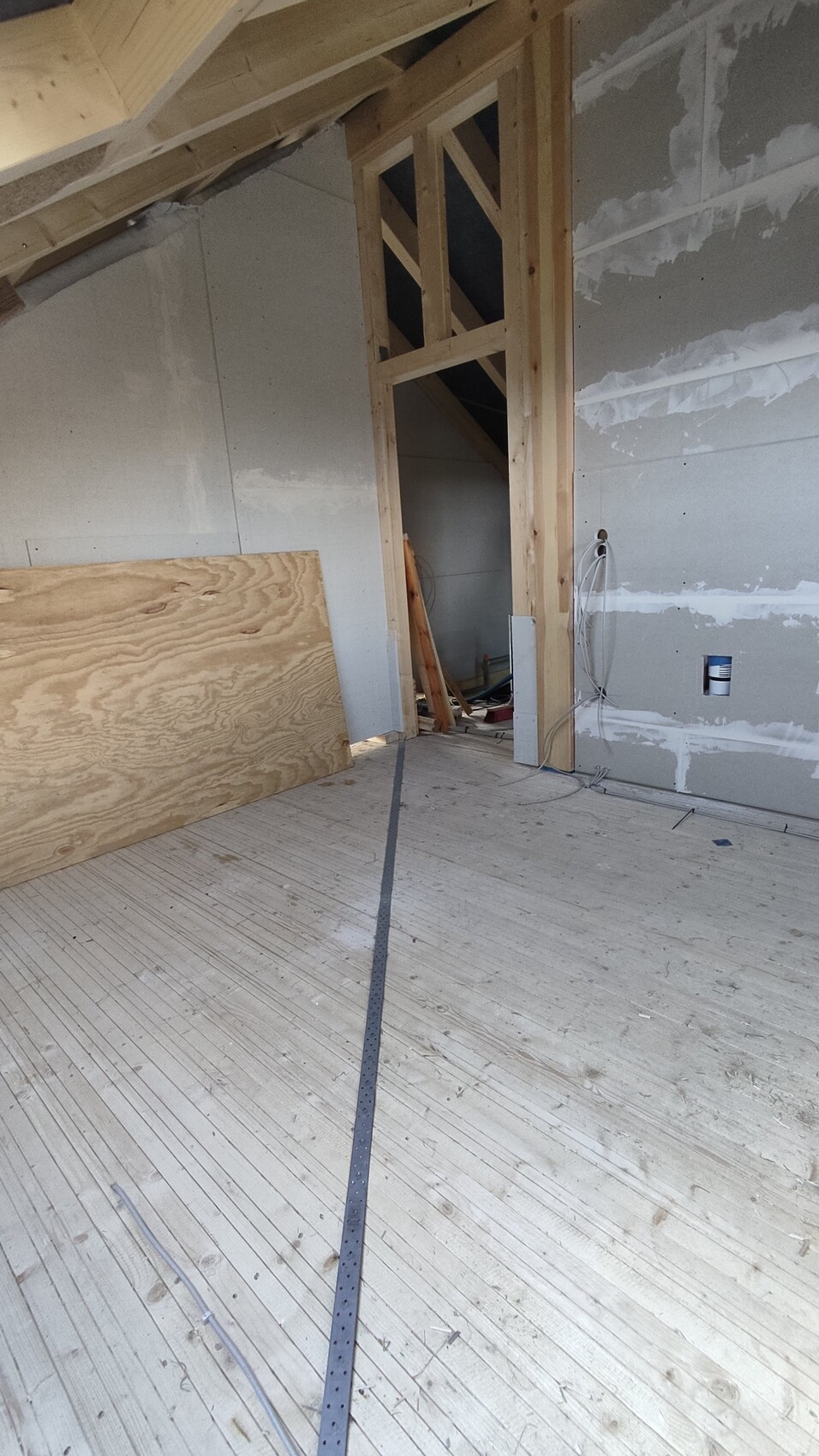 Dachgeschoss-Bau: Holzständerwerk, OSB-Platte, lose Kabel, unfertige Wände.
