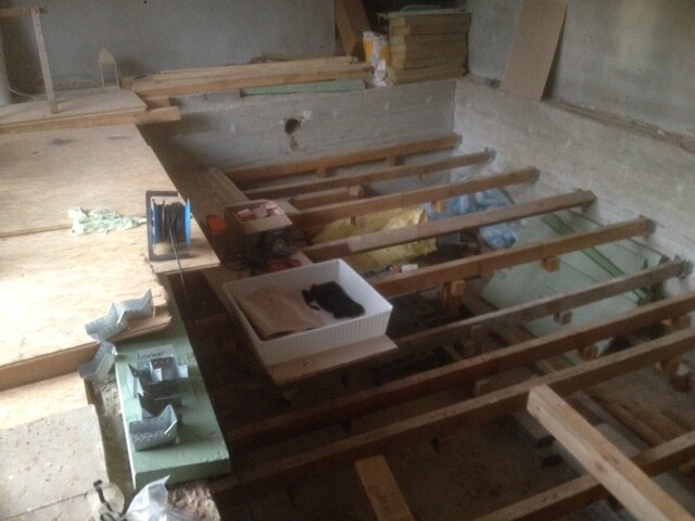Innenraum-Baustelle mit Holzbalken-Tragsystem und Werkzeugen