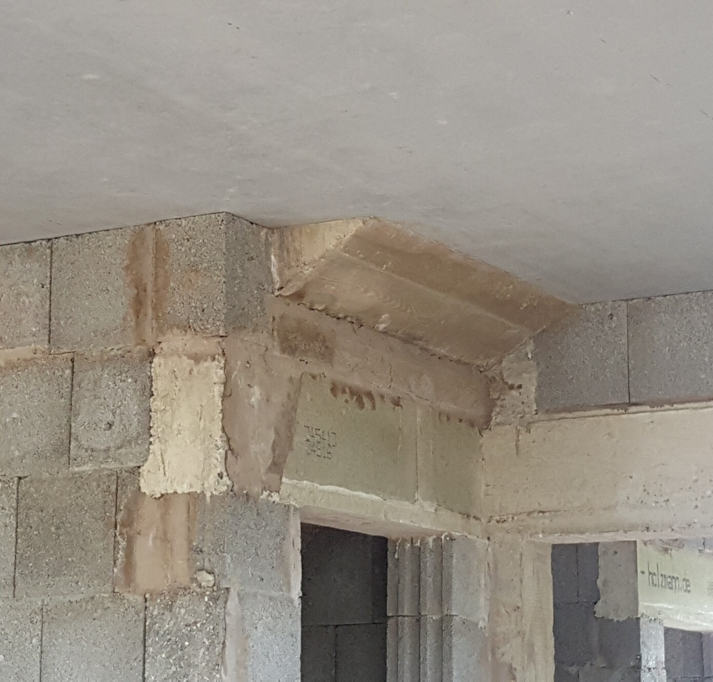 Rohbau-Innenraum mit Betonblock-Wänden, sichtbares Mauerwerk und Türdurchbruch