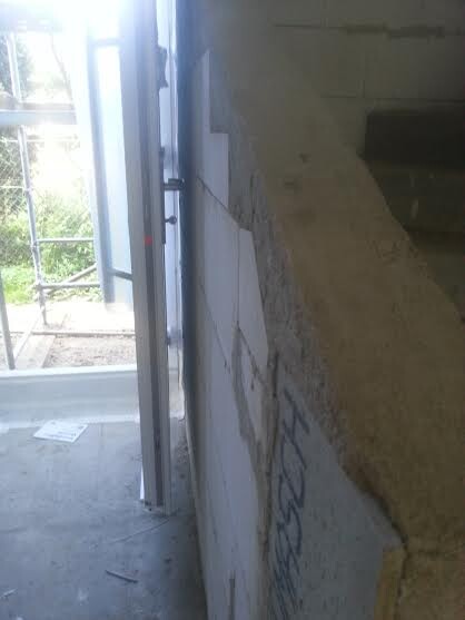 Unverputzter Innenbereich mit offener Wand und Fensterrahmen im Rohbau