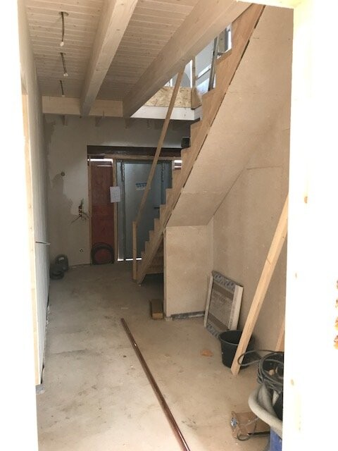 Unfertiger Innenbereich eines Rohbaus mit Treppe