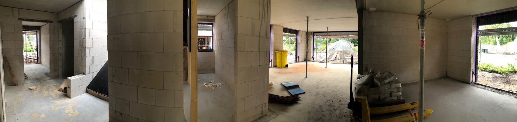 Panorama einer Baustelle: Innenraum aus Betonblöcken, Pfeiler, Materialien und Bauarbeiten.