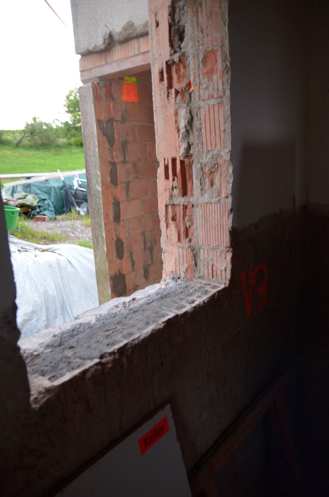 Rohbau: freigelegter Backsteinwandabschnitt mit Mörtel und Blick ins Freie