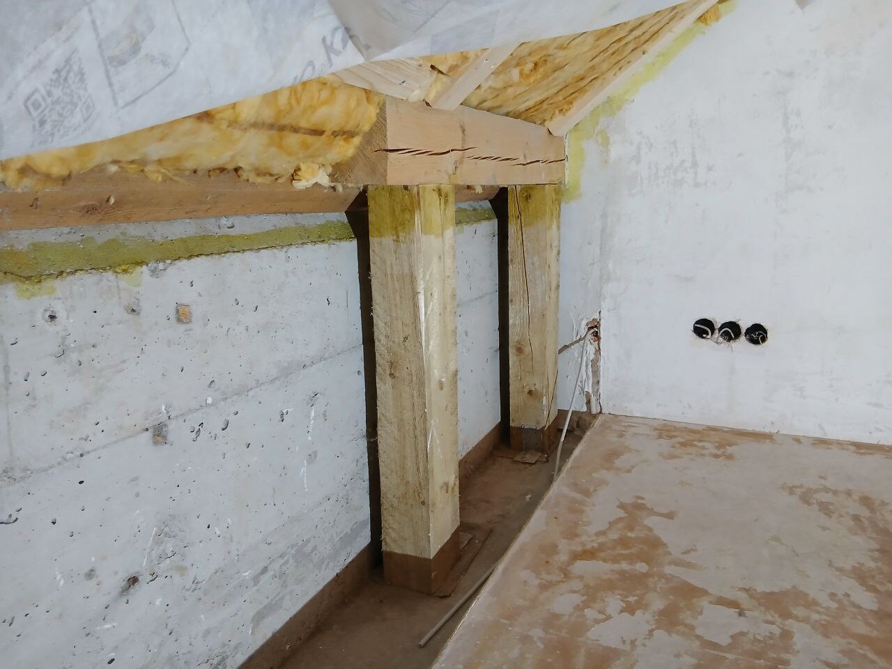 Keller-Rohbau mit Holzbalkenstützen, unverputzte Wände und Boden.